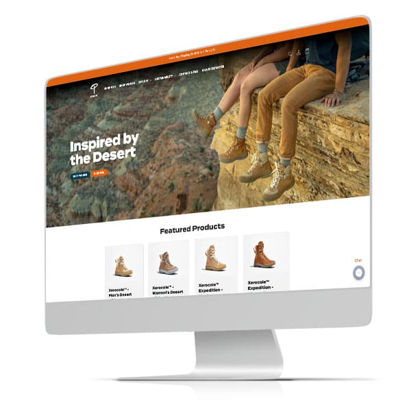 Outdoor footwear ecommerce homepage on desktop screen showing 'Inspired by the Desert' and featured hiking boots.