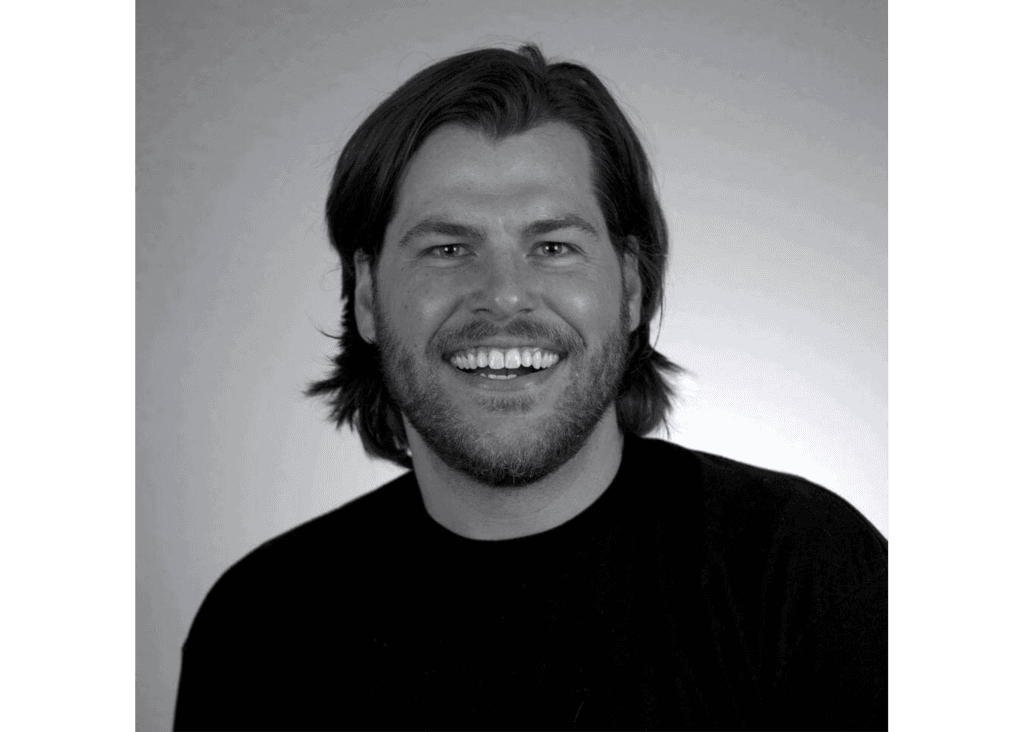 Black-and-white headshot portrait of Brian smiling in a t-shirt