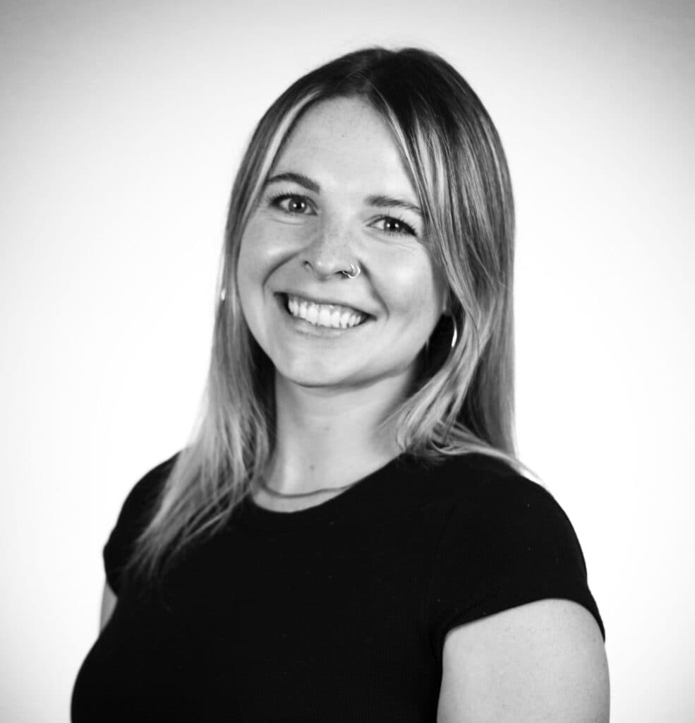Black-and-white portrait of a smiling woman with long blonde hair