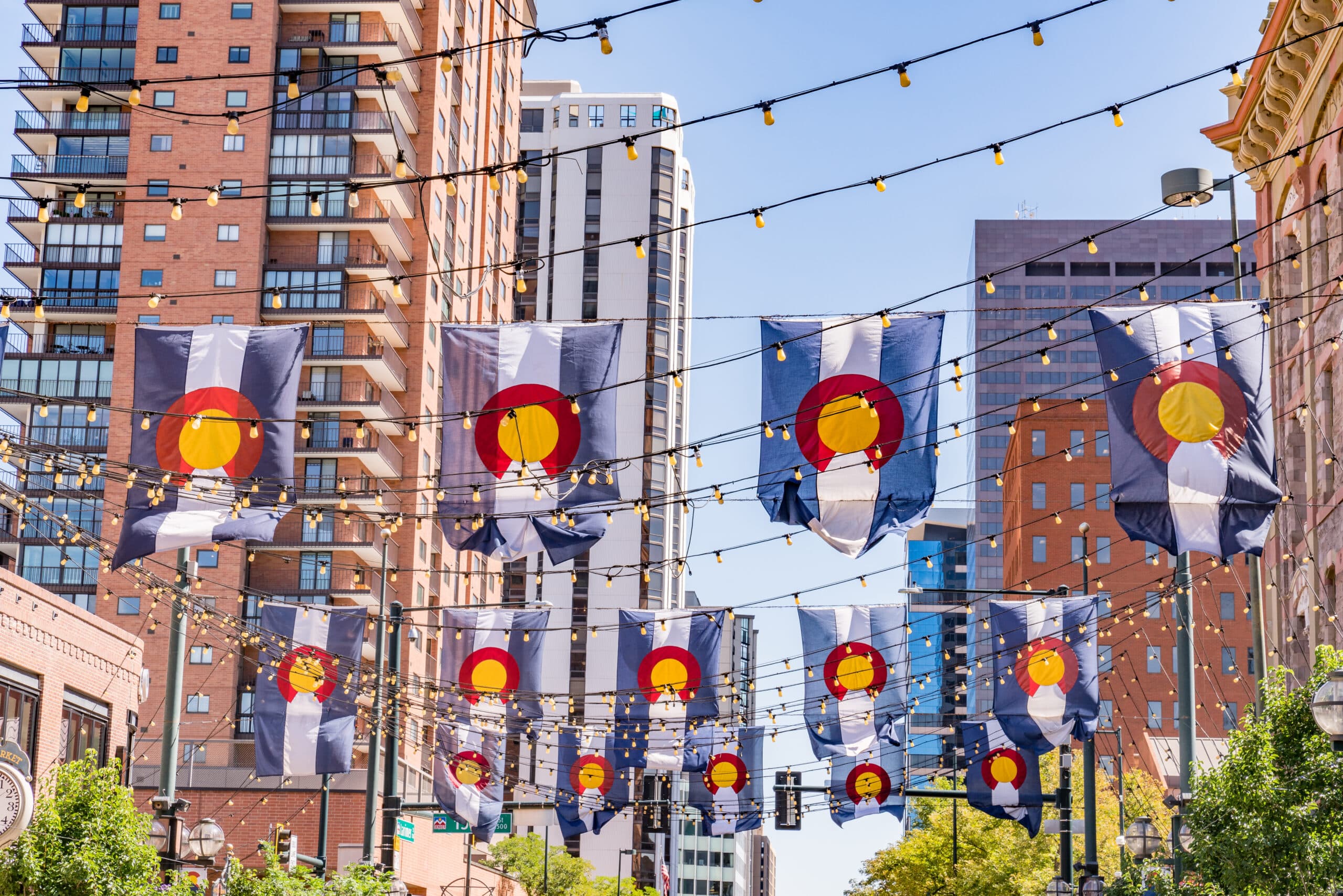 Colorado flags and string lights strung above Larimer Square shops in Denver
